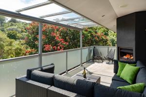 balcón con sofá y chimenea en Double Bays Beauty - Stay Waiheke, en Waiheke Island 6 fotos más