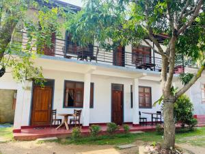 a building with a balcony and a table on it at Parakum Rest Rooms in Polonnaruwa