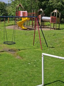 a playground with a swing set in a park at Forest Valley Holiday Home in Ballantrae
