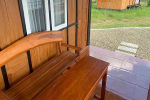 a wooden bench sitting in front of a window at Capital O 93437 Embung Banteran CottageNearLapangan Banteran in Banyumas +16 photos