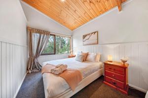 una camera con un grande letto e un soffitto in legno di Rustic Treehouse - Aireys Inlet ad Aireys Inlet