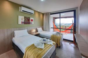 a hotel room with two beds and a balcony at Wai Wai Cumbuco Vista Lateral Mar 2 Quartos in Guagiru +53 photos