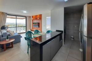 a kitchen with a refrigerator and a living room at Wai Wai Cumbuco Vista Lateral Mar 2 Quartos in Guagiru