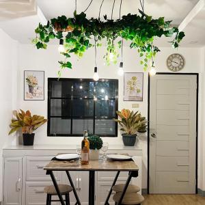 a dining room with a table and potted plants at Tinanom by Kutys Inn in Canaman +3 photos