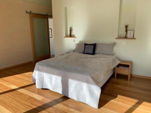 a bedroom with a large bed and a wooden floor at Hundred Acre Woodland Retreat in Wilyabrup