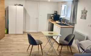 a kitchen with a table and two chairs and a counter at Studio Zen in Barbaggio