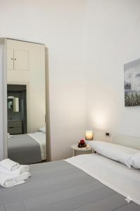 una camera con due letti e un grande specchio di Casa Vacanza La Fornace Matera centro a Matera