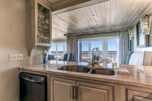 Una cocina con fregadero y vista al mar. en Oceans Of Amelia Condo, en Fernandina Beach 18 fotos más
