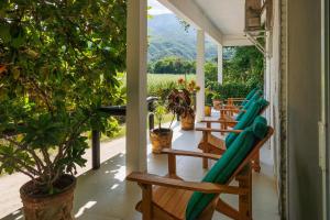 a porch with chairs and hammocks on it at Casa Soñada a la Orilla del Rio in Conca