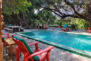 a swimming pool with two chairs and a table at Casa Soñada a la Orilla del Rio in Conca