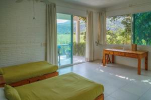 a room with two beds and a desk and a window at Casa Soñada a la Orilla del Rio in Conca +18 photos