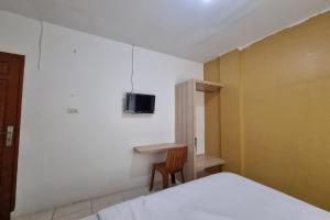 a bedroom with a bed and a tv on the wall at Hotel O Wira Residensia Syariah in Medan +16 photos
