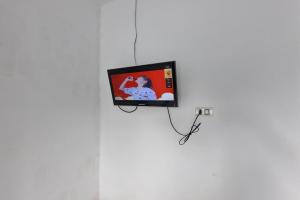 a tv on a wall in a room at Hotel O Wira Residensia Syariah in Medan