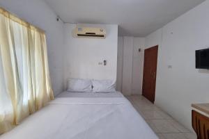 a bedroom with a large white bed in a room at Hotel O Wira Residensia Syariah in Medan