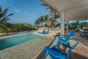 a pair of blue chairs sitting next to a swimming pool at PLAYA Picheta Telchac Beach Front in Telchac Puerto