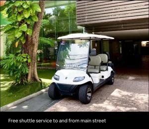 een witte golfkar geparkeerd voor een huis bij Executive Suite 1BR and Sofa Bed 150m to Nana BTS in Bangkok