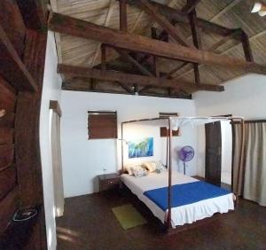 a bedroom with a bed in a room with wooden ceilings at Square de Vohémar in Vohemar