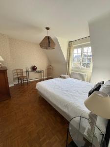 een slaapkamer met een bed, een tafel en een raam bij Maison Hyper centre Dinan 2,4 ou 6 personnes in Dinan