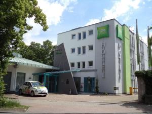 un edificio blanco con un coche aparcado delante de él en ibis Styles Speyer, en Speyer
