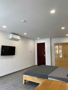 a bedroom with a bed and a flat screen tv at Maison Mia Hotel & Apartment in Ga Tân Thiết