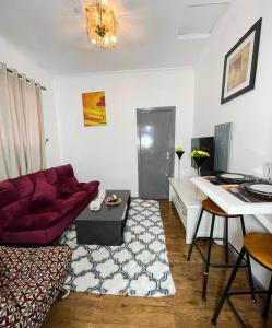 a living room with a red couch and a table at Woods Cottage Kilimani in Nairobi