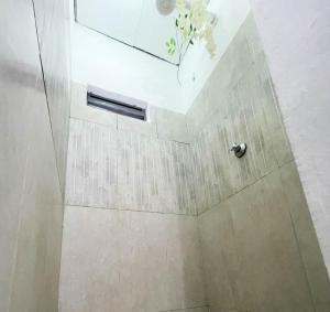 a bathroom with a shower with a white tile wall at Woods Cottage Kilimani in Nairobi +16 photos