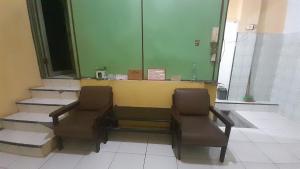 a waiting room with two chairs and a counter at Hotel O Kamboja Homestay Syariah in Delitua +20 photos