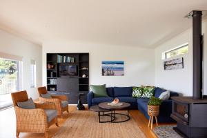 a living room with a blue couch and chairs at Ruru House in Auckland