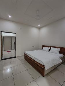 a white room with a bed and a mirror at Prem NATH Homestay in Garudeshwar
