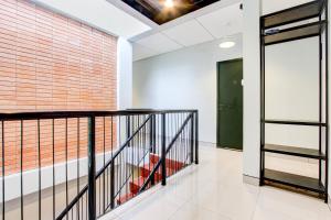 a hallway with a staircase and a brick wall at Hotel O Rubina Syariah Hotel in Purbolinggo