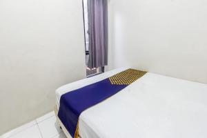 a bed in a white room with a window at Hotel O Penginapan Melati Tanjung Near Kantor Pengamat Pengairan Tanjung in Papak