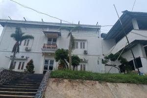 a white house with stairs in front of it at Hotel O Umbuy Homestay NearKetupat Kandangan Haji Irus in Rantau