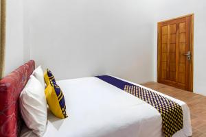 Ένα ή περισσότερα κρεβάτια σε δωμάτιο στο Hotel O Kebun Manis Homestay Near Lapangan Bola Volly Batu Kumbung