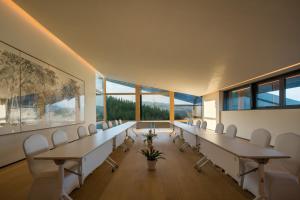 a conference room with tables and chairs and large windows at Xiang Yue Lake International Resort in Deqing +134 photos