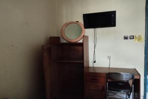 a desk with a mirror and a chair in a room at Hotel O Pondok Gusang Kuala Near Pelabuhan H Basran in Pagatan