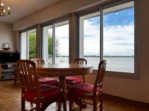 jadalnia ze stołem, krzesłami i oknami w obiekcie Maison 3 pièces, vue Ria d'Étel, jardin clos, proche mer et plages - FR-1-397-71 w mieście Locoal-Mendon