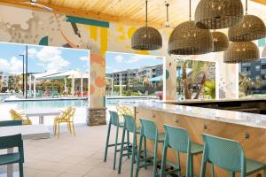 a restaurant with a bar with chairs and a pool at Villatel Orlando Resort in Orlando +5 photos