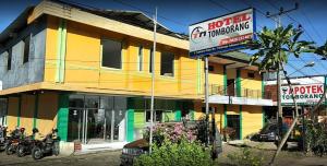 a colorful building with motorcycles parked in front of it at OYO 93411 Syariah Hotel Tomborang in Karema
