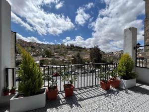 a balcony with potted plants and a view of a city at Zaman Ya Zaman Boutique Hotel in Amman