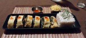 a tray of sushi and rice on a table at Square de Vohémar in Vohemar
