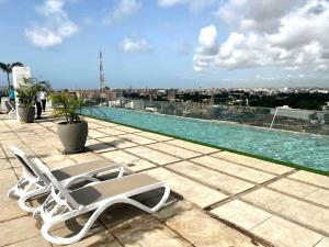 a lounge chair sitting on the roof of a building at Luxurious Apt with Rooftop Pool in Dakar