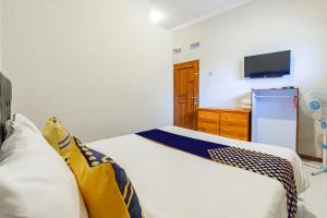 ein Schlafzimmer mit einem Bett und einem Fernseher in der Unterkunft Hotel O Triple N Homestay in Sidoarjo + 22 Fotos