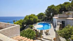 a view of a house with a swimming pool and the ocean at Unglaubliche Villa mit Meerblick und Pool in Font de Sa Cala