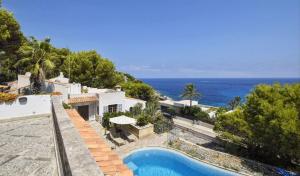 a house with a swimming pool next to the ocean at Unglaubliche Villa mit Meerblick und Pool in Font de Sa Cala
