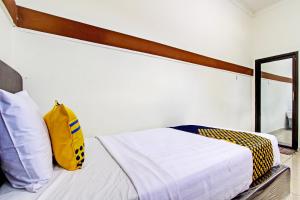 プルウォケルトにあるHotel O Juan Kostel 2のベッドルーム1室(黄色いバッグ付きのベッド1台付)