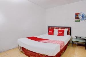 a bedroom with a large bed with red pillows at Hotel O Homestay Bambu Oerip Syariah in Yogyakarta