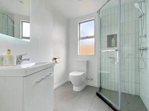 オークランドにある6mins to airport Large Family Houseのトイレとガラスのシャワー付きのバスルーム