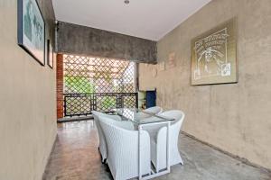 a dining room with white chairs and a table at Hotel O Penak Malioboro Bunk Bed in Yogyakarta
