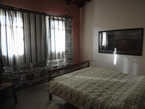 a bedroom with a bed and a tv on the wall at The Castle's Key in Volissos