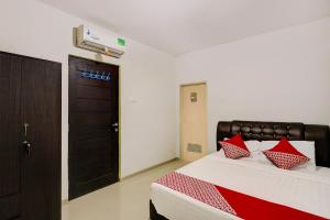 une chambre avec un lit avec des oreillers rouges dessus dans l'établissement Hotel O Sir Homestay, à Nagoya 18 autres photos